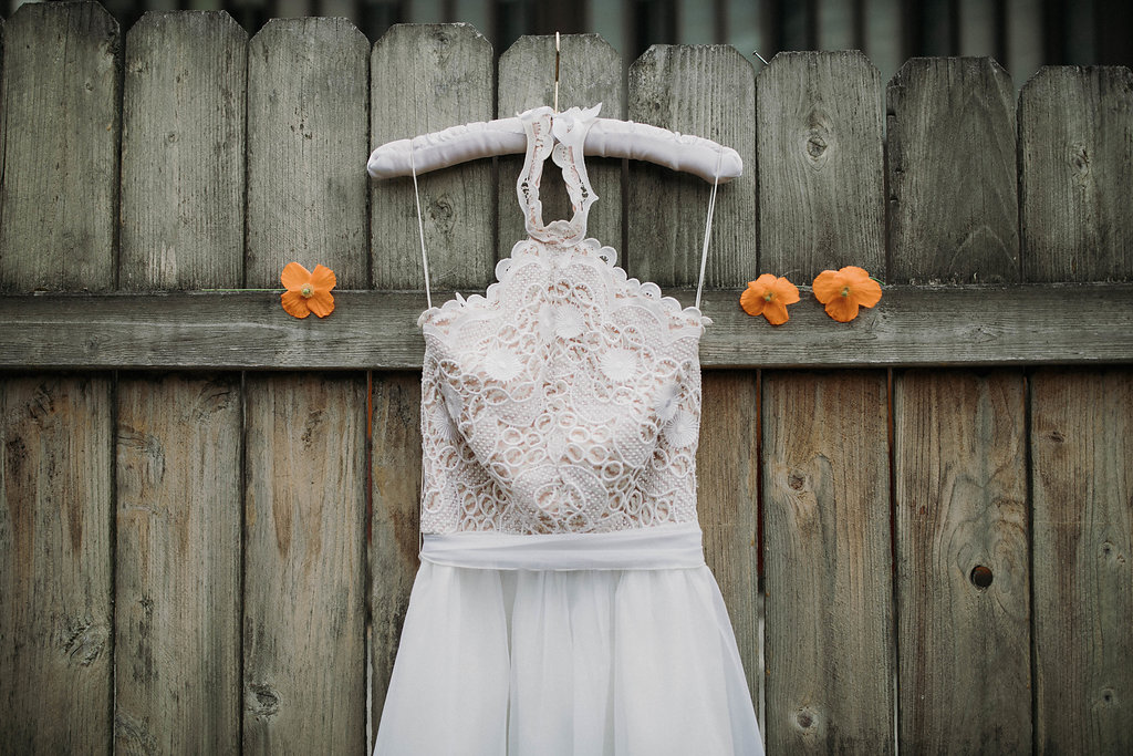 Vintage Bridal Dress hanging on a wooden fence. 