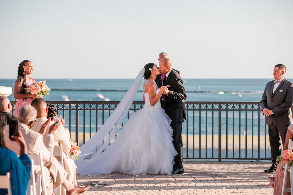 African American Married couple shared an I DO kiss at the end of the ceremony on the Captain's Deck at the Emerald Grande Resort in Destin, Florida