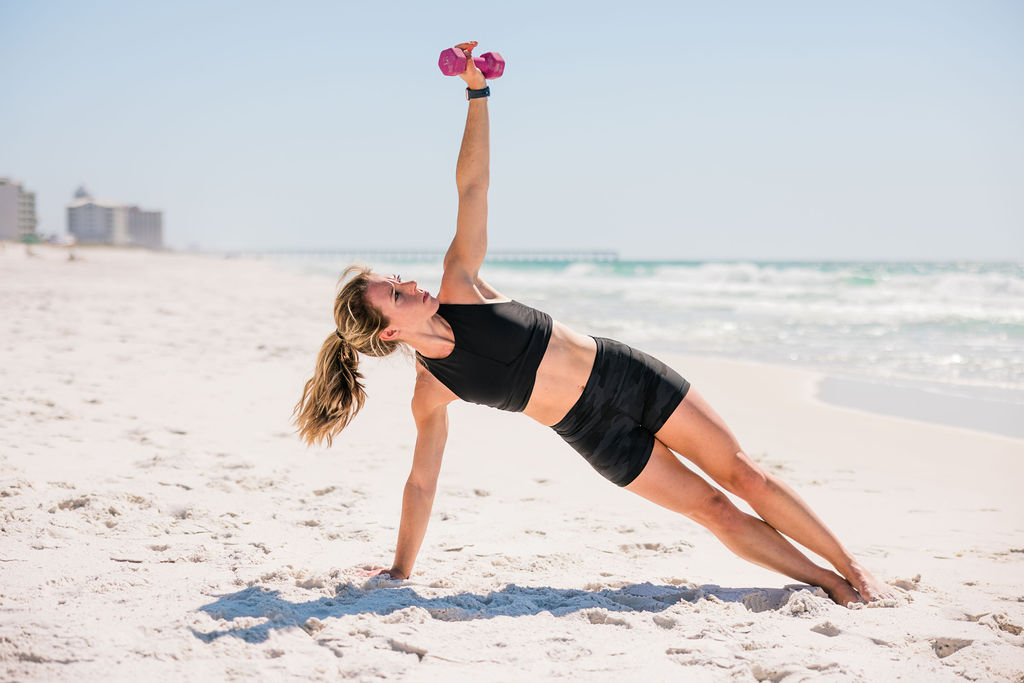 Woman athlete working out on sand during an outdoor female beach fitness photoshoot in Pensacola Beach, Florida. 