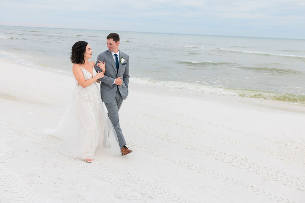 Couple walking on the beach after the ceremony during Destin Wedding photoshoot at the Henderson Resort in Destin, Florida during the pandemic COVID-19. The Henderson Beach Resort Wedding in Destin, Florida by Destin Wedding Photographer, Weddings by Adina Photography. 