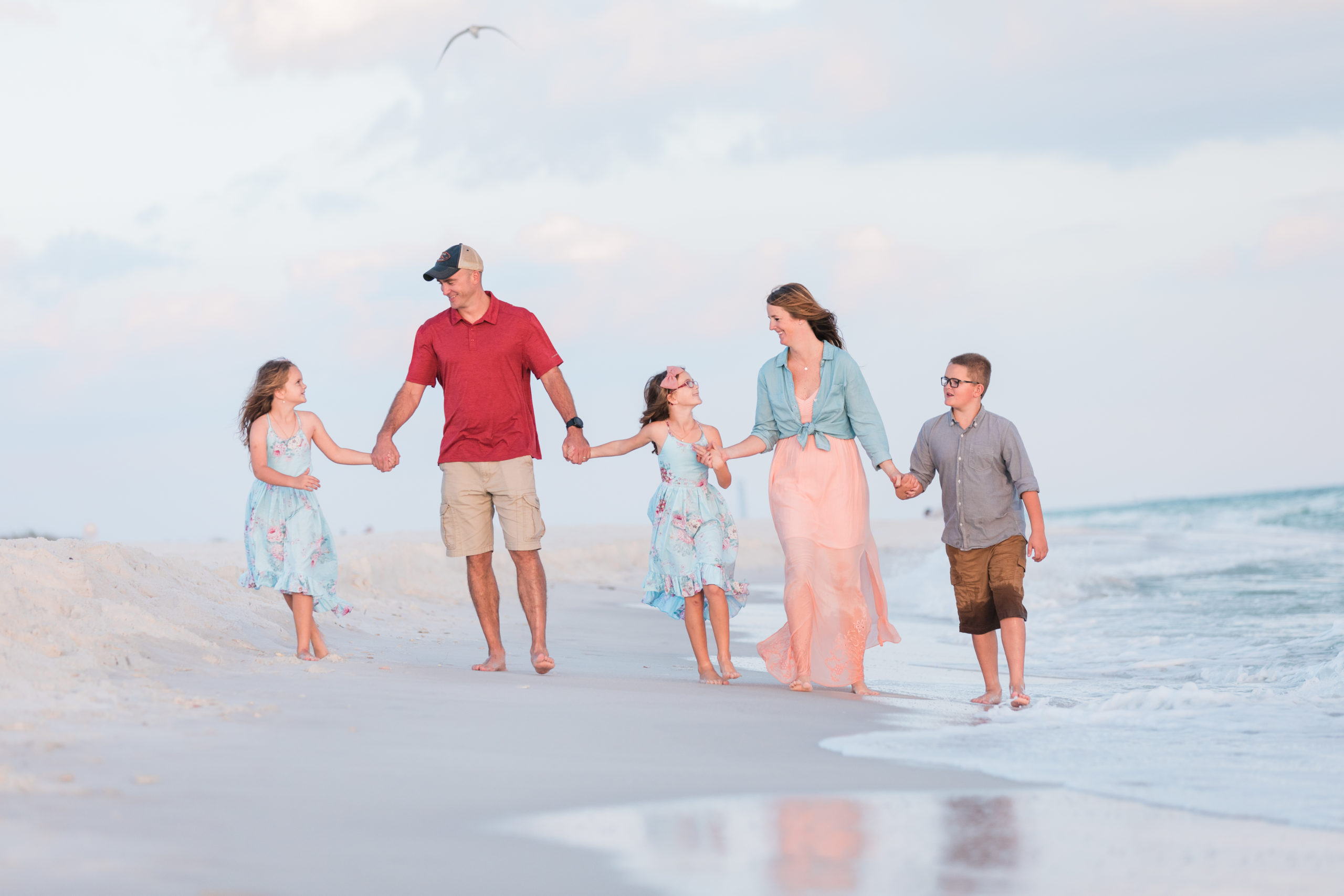 Family walking on the beach in Navarre, Florida for a photography session at sunset