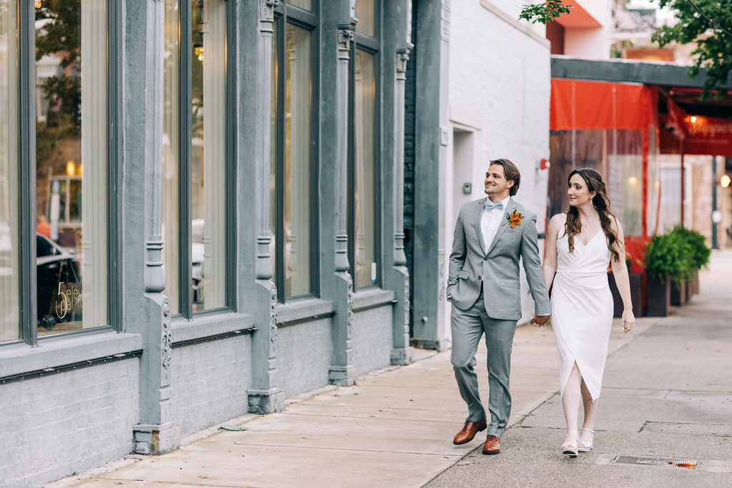 Married Couple walking in front of 5-Eleven Palafox Wedding venue