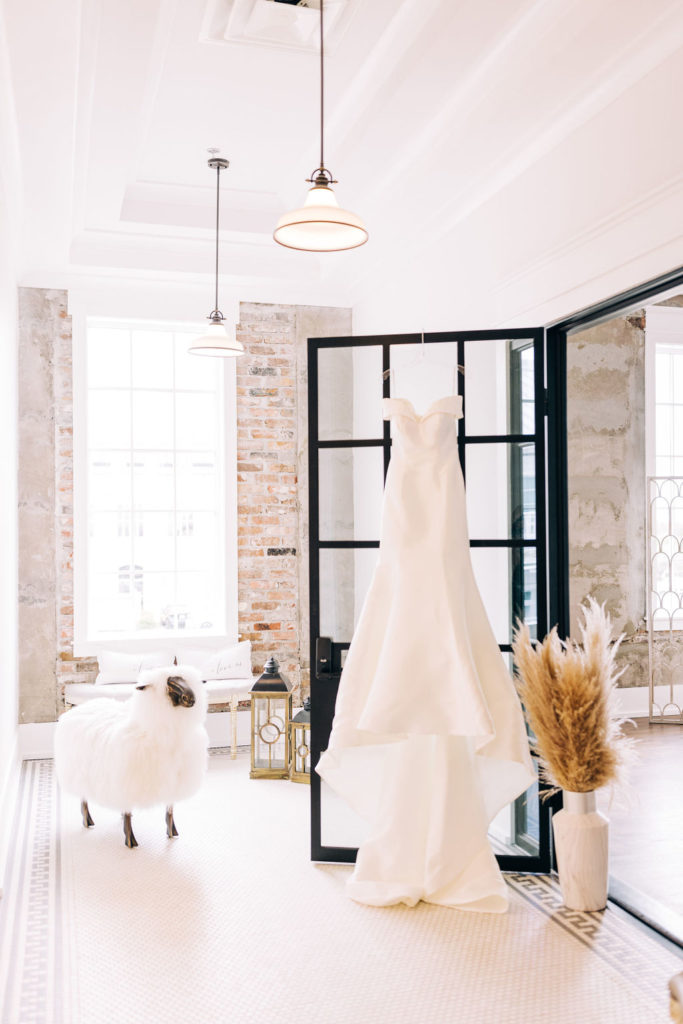 5-Eleven Palafox Bridal Suite - Wedding dress hanging on the door next to the fuzzy sheep