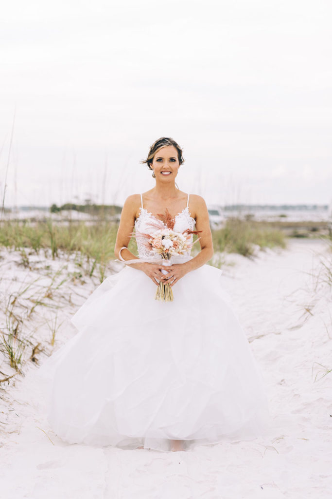 Bride posing on the beach during her wedding in Pensacola Beach.