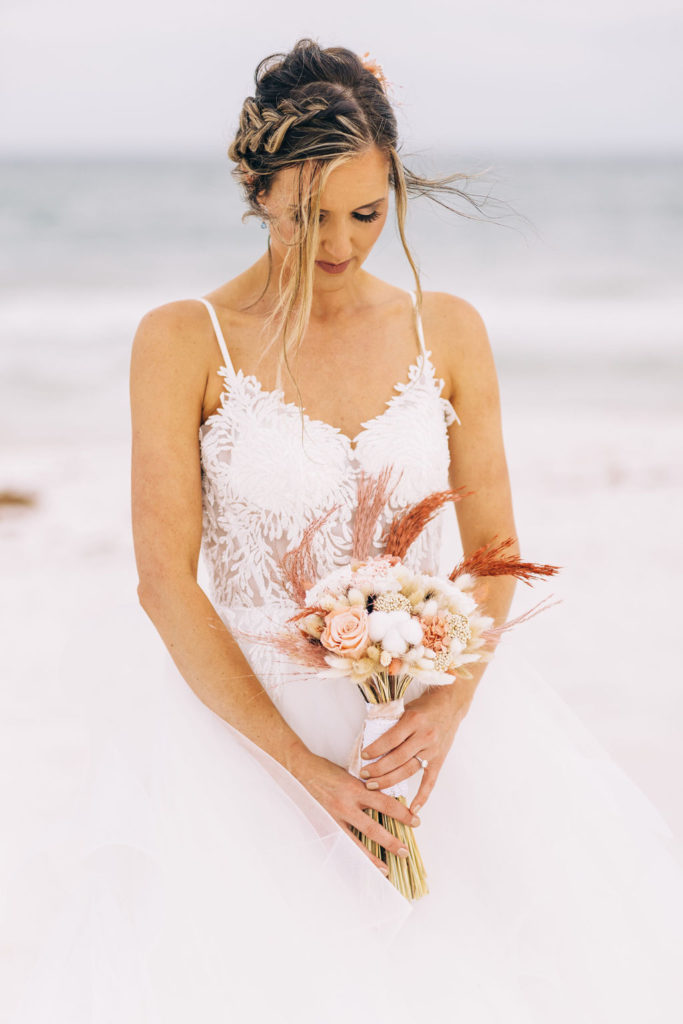Bride holding wedding flower bouquet during her photography session in Pensacola Beach.
