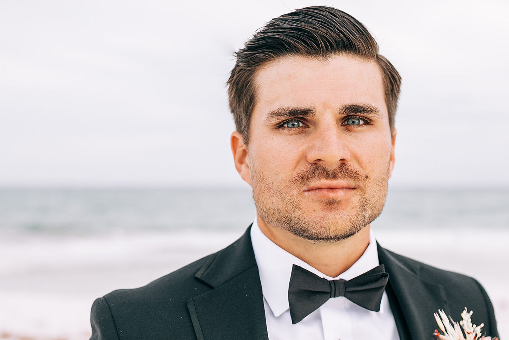 Groom close-up portrait in Pensacola Beach during his elopement at sunset.