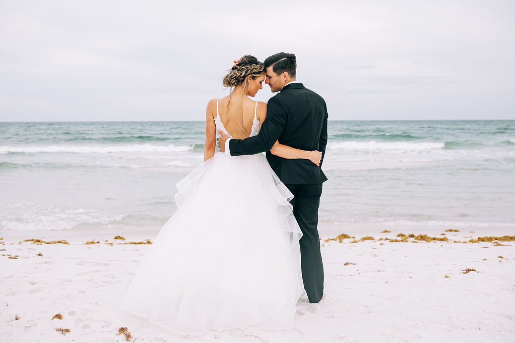 Bride and Groom embracing on the beach in Pensacola Beach during their elopement at sunset.